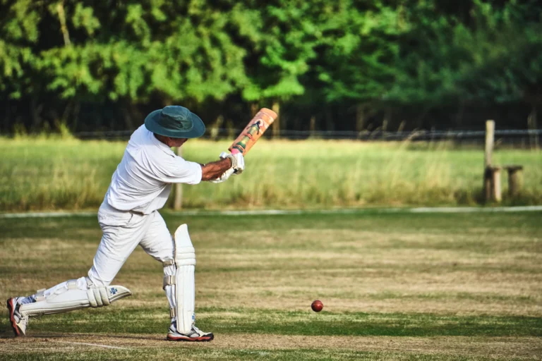 Batter in whites playing a drive