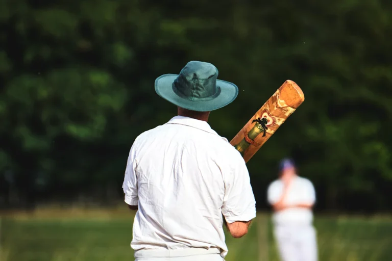 Cricketer holding a bat on the boundary