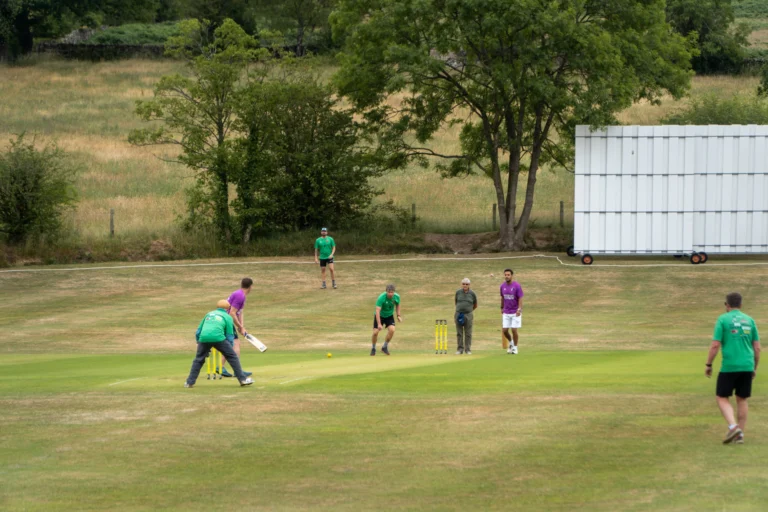 Amateur cricketers playing a friendly league match on a summer afternoon